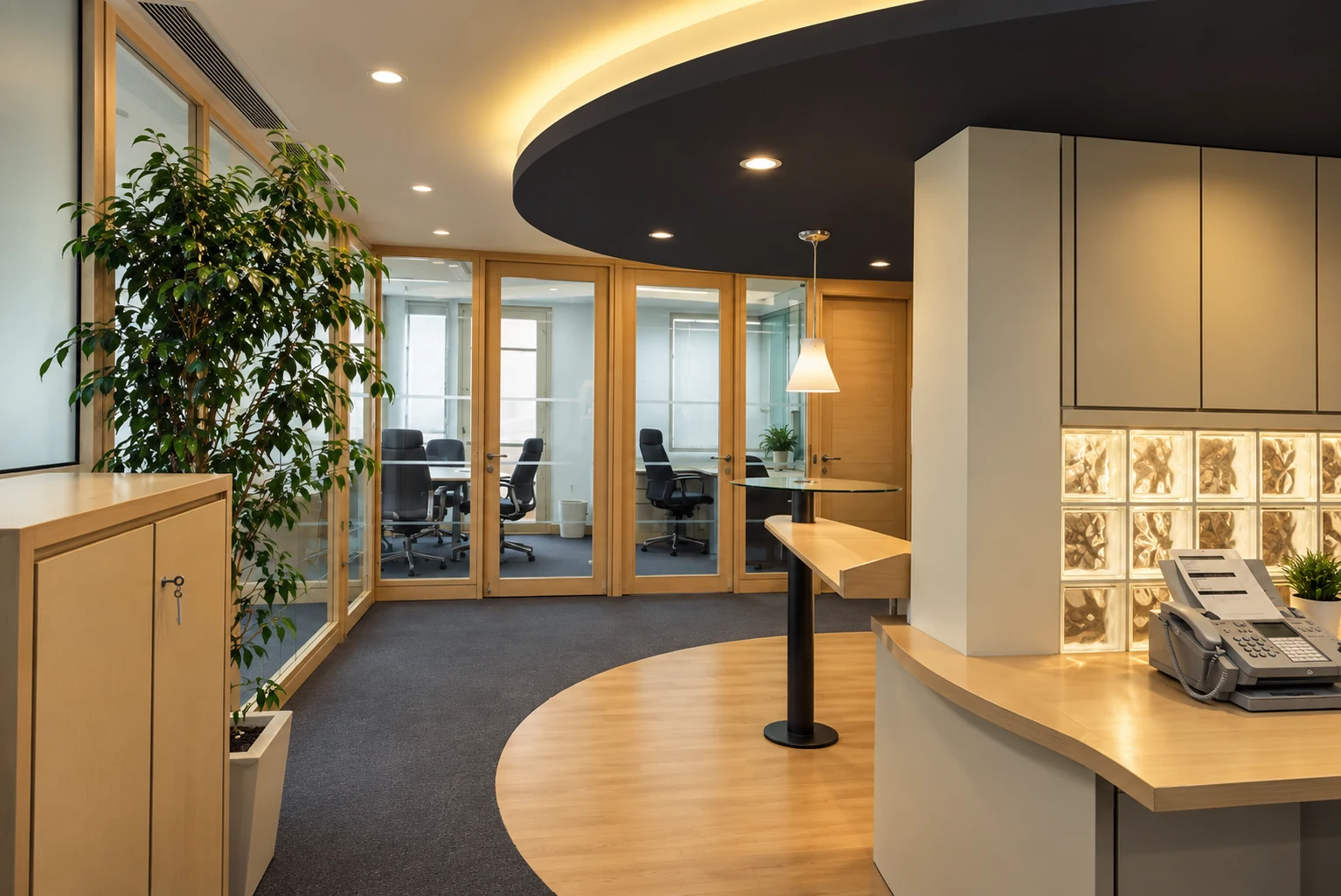 Office collaboration space beside glass-partitioned meeting rooms