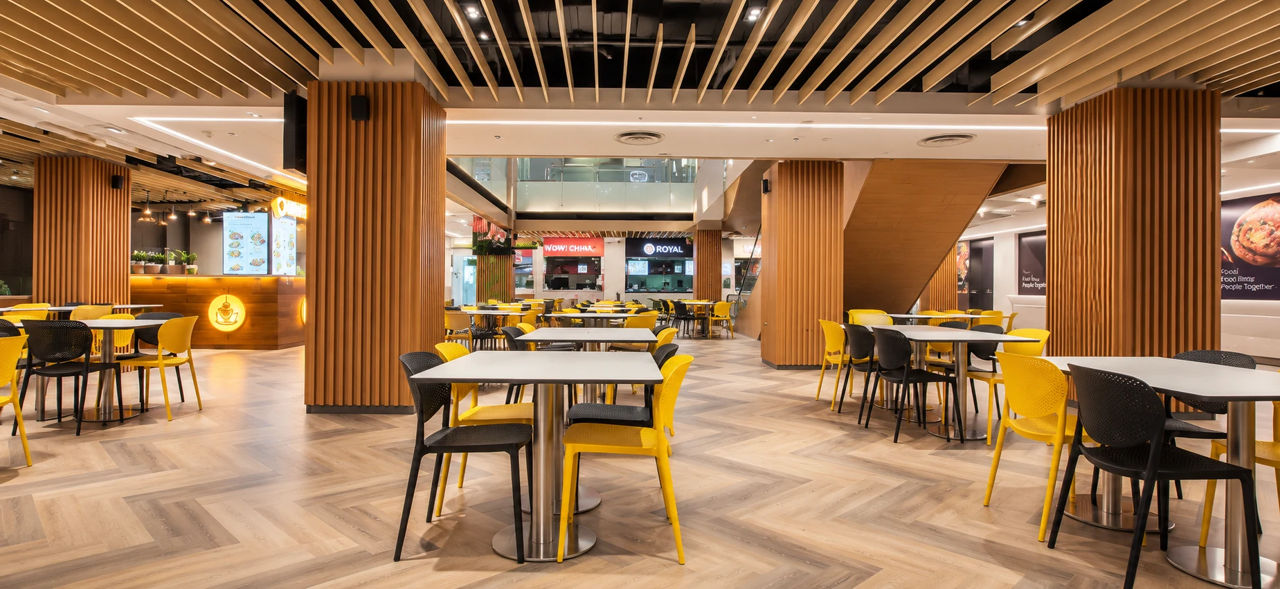 Food court dining area with timber ceiling slats and yellow chairs